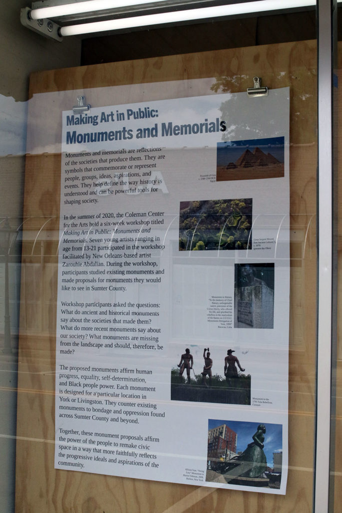 Text panel attached to plain, unfinished plywood behind storefront window